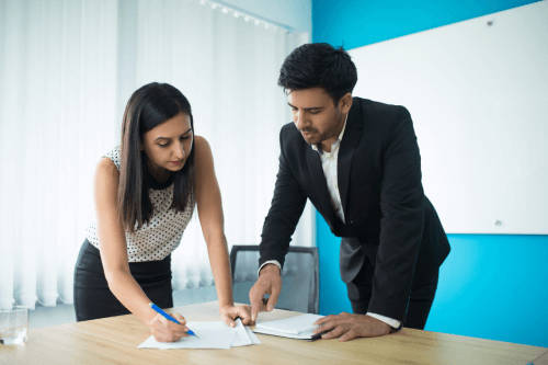 serious businessman businesswoman signing contract 1 scaled 1